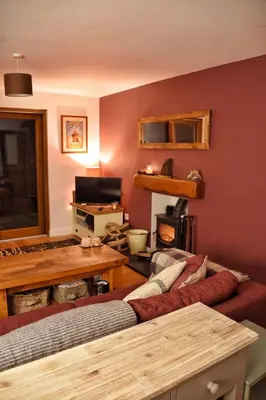 a living room with a couch and a table at Cosy Cottage in Glencoe