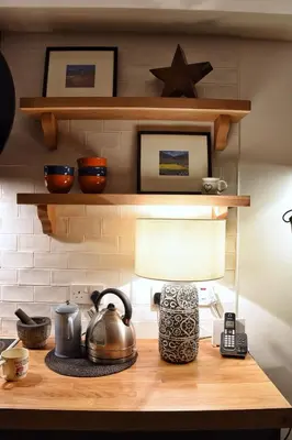 a table with a tea kettle and a phone on it at Cosy Cottage in Glencoe