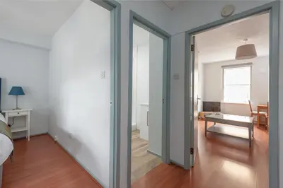 a bedroom with a sliding glass door leading to a living room at The Wee Highland Coo in Edinburgh