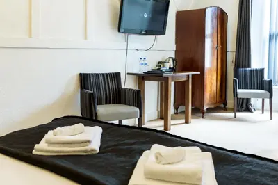 a hotel room with a bed with towels on it at The Crown Hotel in Newton Stewart