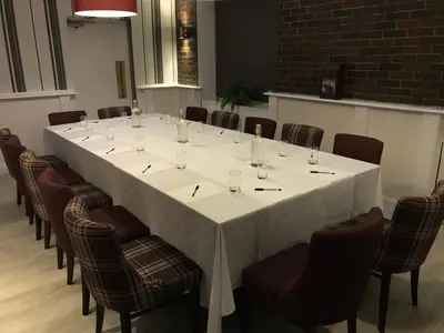 a large white table in a room with chairs at The Crown Hotel in Newton Stewart