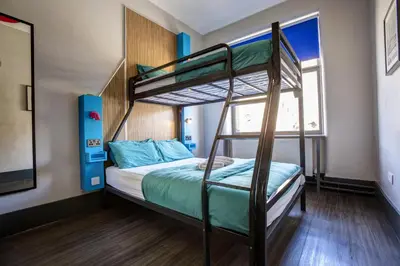 a bedroom with two bunk beds and a window at Kick Ass Grassmarket (18+) in Edinburgh