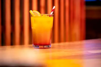 a drink sitting on a table with a lemon slice at Kick Ass Grassmarket (18+) in Edinburgh