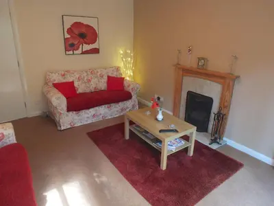 a living room with a couch and a fireplace at Trefoil Holiday Home in Strachur