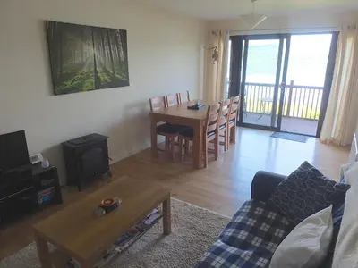 a living room with a couch and a table with a stove at Trefoil Holiday Home in Strachur