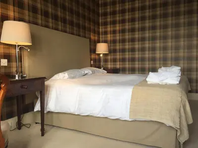 a bedroom with a bed and a table with two lamps at Glenburnie House in Oban