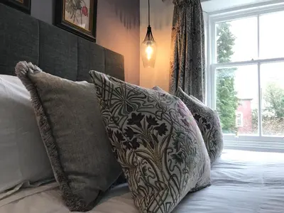 a bedroom with a bed with pillows and a window at The Cottage in Dunblane