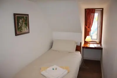a small bedroom with a bed and a window at Highland House Callander in Callander
