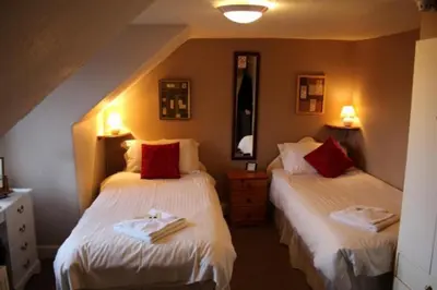 a bedroom with two beds with towels on them at Highland House Callander in Callander