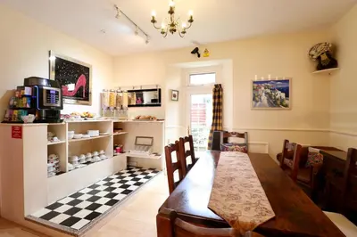 a dining room with a table and a checkered floor at Highland House Callander in Callander