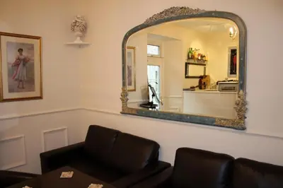 a living room with a mirror and a couch at Highland House Callander in Callander