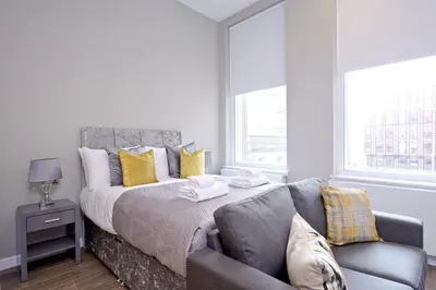 a bedroom with a bed and a couch at Nelson Mandela Place Apartments in Glasgow