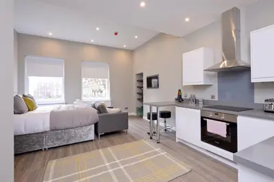 a kitchen and living room with a bed and a couch at Nelson Mandela Place Apartments in Glasgow