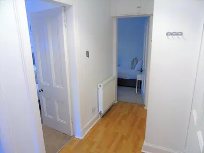 a hallway with a room with a bed and a door at Snug - Tùr Sealladh Apartment in Helensburgh