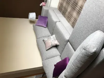 a gray couch with purple pillows sitting next to a table at Greannan Upper Self Catering Apartment in Blackwaterfoot