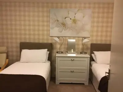 a bedroom with two beds and a nightstand between them at Ingleneuk Bed and Breakfast in Edinburgh