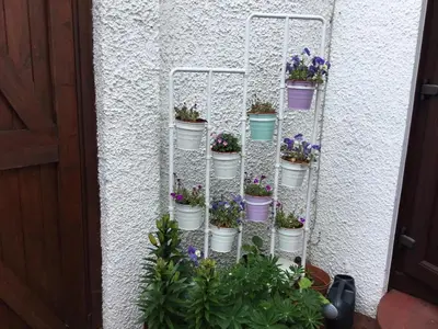 a vertical garden with flowers in buckets on a wall at Ingleneuk Bed and Breakfast in Edinburgh