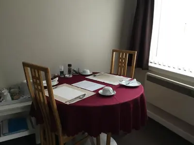 a table with a red table cloth and two chairs at Ingleneuk Bed and Breakfast in Edinburgh