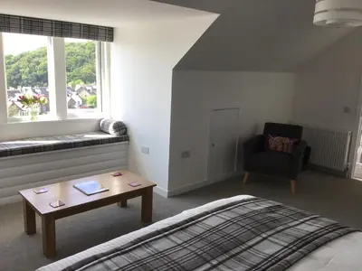 a bedroom with a bed and a table and a chair at Gramarvin B&B in Oban