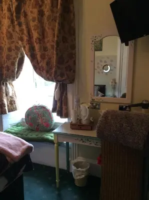 a bedroom with a window and a table with a window seat at Lagganbeg Guest House in Oban
