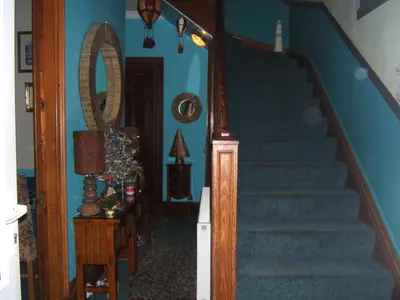a staircase in a house with a blue wall at Lagganbeg Guest House in Oban