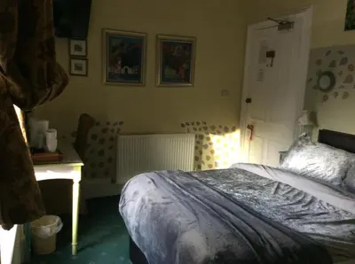 a bedroom with a bed and a desk in it at Lagganbeg Guest House in Oban