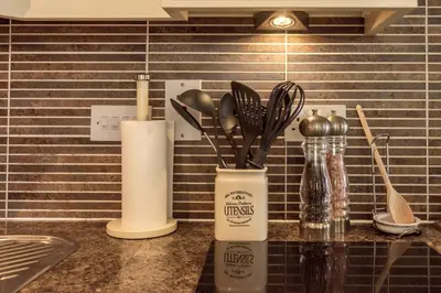 a kitchen counter with a container of utensils on it at Marina View Apartment in Inverkip