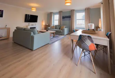 a living room with a couch and a table at Marina View Apartment in Inverkip