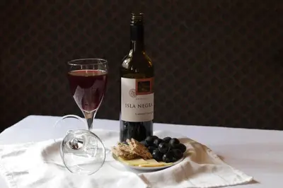 a bottle of wine and a plate of grapes and a glass at Thistle Hotel in Edinburgh