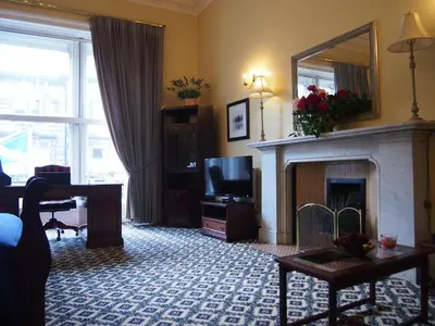 a living room with a fireplace and a television at Thistle Hotel in Edinburgh