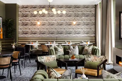 a restaurant with couches and tables and a brick wall at Heeton Concept Aparthotel Edinburgh Queen Street in Edinburgh