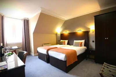 a hotel room with a large bed and a window at Columba Hotel in Oban