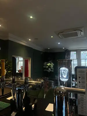 a restaurant with a table with bottles of wine at The Popinjay Hotel in Larkhall