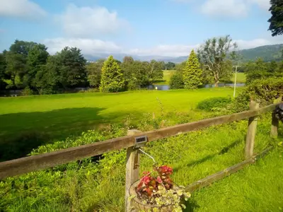 a fence with flowers on it in a field at Callander Woods Holiday Park in Callander