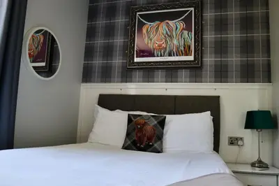 a bedroom with a bed with a cow pillow on it at Harbourside Hotel in Irvine