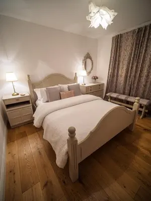 a bedroom with a large white bed and a mirror at Taymore Lodge in Kenmore