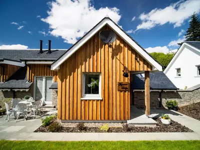 a wooden house with a patio at Taymore Lodge in Kenmore