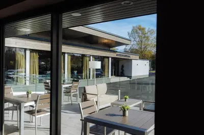 a patio with tables and chairs in front of a building at The Redhurst Hotel Glasgow in Giffnock