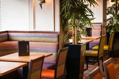 a restaurant with tables and chairs and a potted plant at Leonardo Inn Glasgow West End in Glasgow