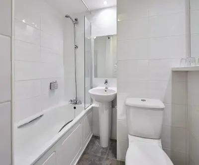 a white bathroom with a toilet and a sink at Leonardo Inn Glasgow West End in Glasgow