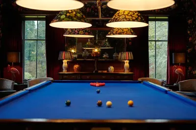 a pool table in a living room with lights at Cromlix in Kinbuck