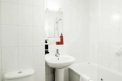 a white bathroom with a sink and a bath tub at Muthu Queens Hotel, Oban in Oban