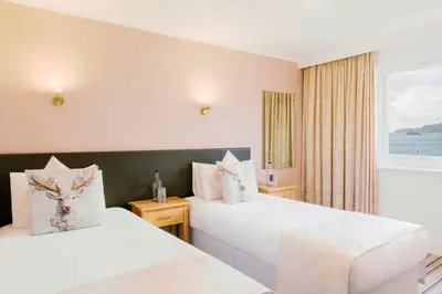a hotel room with two beds and a window at Muthu Queens Hotel, Oban in Oban