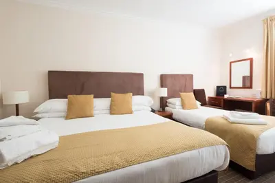 a hotel room with two beds with yellow pillows at Pitbauchlie House Hotel - Sure Hotel Collection by Best Western in Dunfermline
