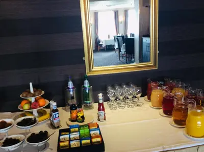 a table with glasses and drinks and a mirror at Pitbauchlie House Hotel - Sure Hotel Collection by Best Western in Dunfermline