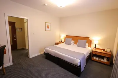 a hotel room with a large bed and two lamps at Pitbauchlie House Hotel - Sure Hotel Collection by Best Western in Dunfermline