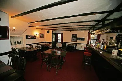 a restaurant with tables and chairs and a bar at Balmoral Hotel in Moffat