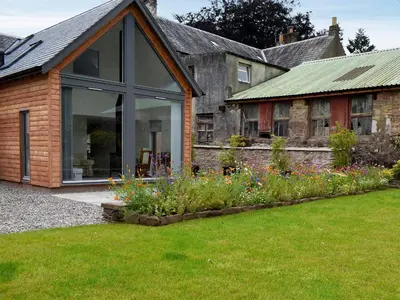 a house with a garden with flowers in the yard at Rowanlea in Muthill