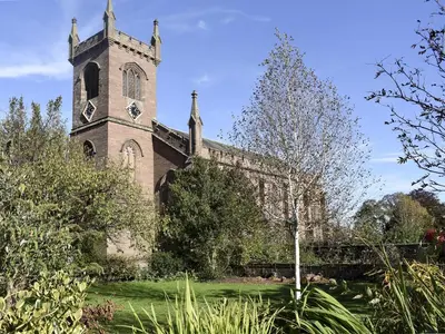 an old church with a tower with a clock on it at Rowanlea in Muthill