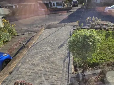 a street with a brick sidewalk with a car on it at Glencairn Rd in Langbank